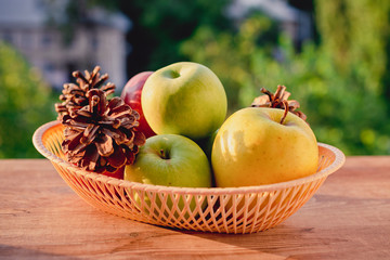 apples in a wicker basket on nature background