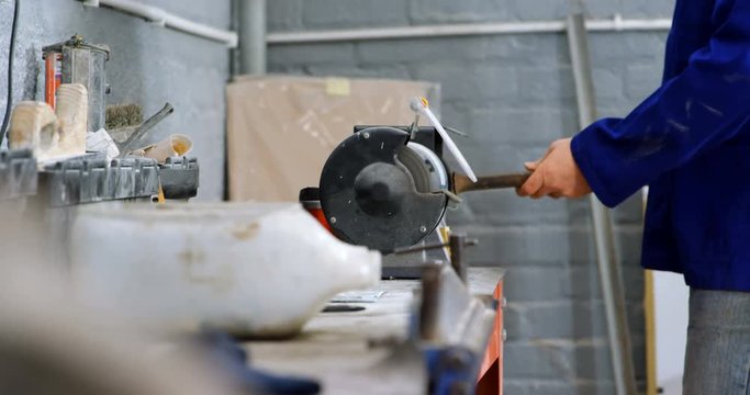 Mechanic using sharpening machine in garage 4k