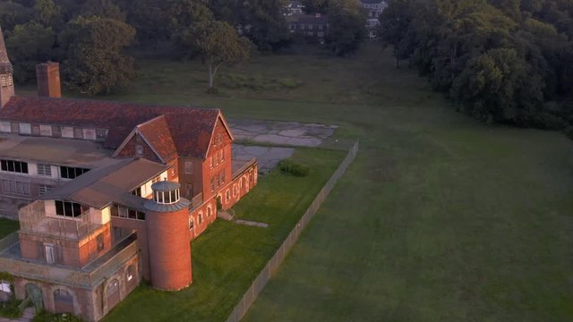 Drone orbit of abandoned sanatorium on beach at sunrise