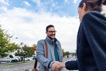 Naklejka premium Businessman and businesswoman are handshaking outdoor