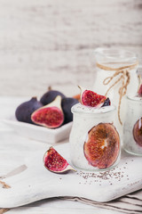 Homemade healthy yoghurt in glass jars with figs and chia seeds