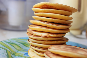 A stack of delicious pancakes is on a blue plate