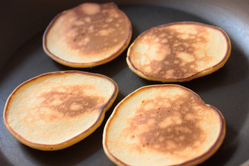 Four pancakes are cooked on a frying pan