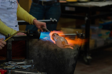 Glass Artist in her workshop making glassware