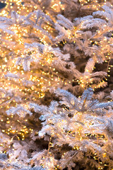 Silver Christmas tree with golden shining garlands, Christmas background. Vertical