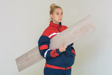 Happy young woman measuring and marking laminate floor tile, installing laminate flooring. Close-up...