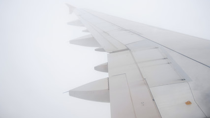 View from illuminator of airplane flying through heavy clouds. Dsnger of flight in bad weather conditions