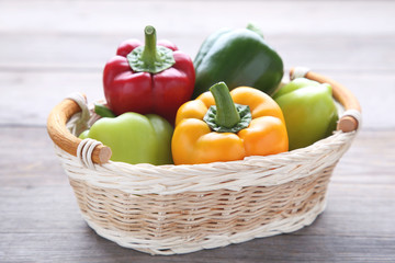 Sweet pepper in a basket on a grey background.