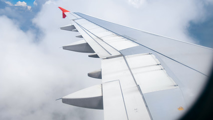 Fototapeta na wymiar Image of airplane wing flying above cloads and blue sky