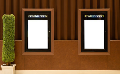 Empty isolated cinema poster panel on the wall of theater walkway, white blank mockup movie frame...