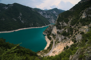 Naklejka na ściany i meble A beautiful view at the Piva lake (Pivsko jezero) going through a valley from a viewpoint located on a nearby hill. Municipality Plužine, Montenegro.