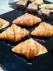Assortment of delicious and buttery croissants made by pastry chef. All look very tasty and delightful. Natural light.
