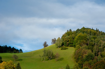 Fototapeta na wymiar Grüner Hügel blauer Himmer