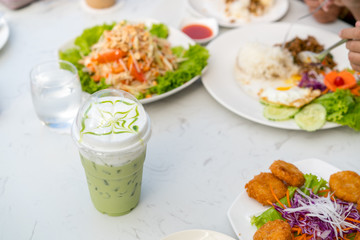 Iced green tea and food on table