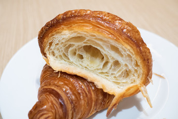 Cross section showing good example of airy honeycomb structure of delicious and buttery Saffron Croissants made by pastry chef. All look very tasty and delightful. Natural light. Close up.