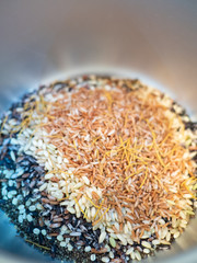 Close up of raw multigrains brown rice in a rice cooker. High in nutrients and good source of vitamin, mineral, antioxidant, anthocyanin, high in fiber. Healthy eating and eat well concept.