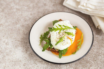 Rye toast with poached egg, dairy cream and arugula