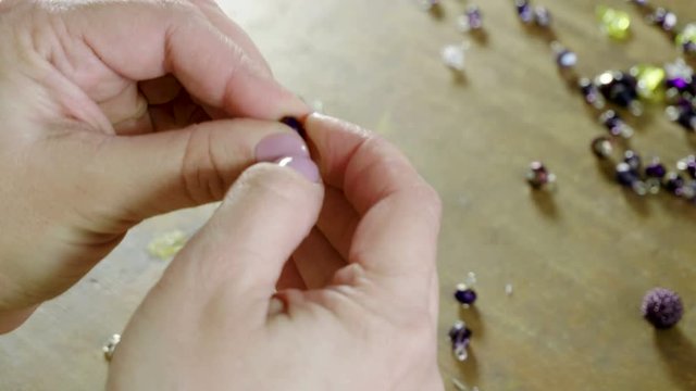 Master jeweler doing women's handmade bracelet from decorative artificial stones and beads. 4K
