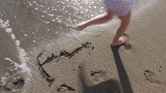 Waves and Child Over the Word Fear Written in Sand