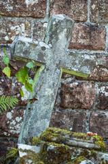 closeup of stoned cross on abandoned tomb in cemetery