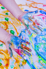 Close up of child girl painting with colorful hands. ( people, childhood, drawing concept)