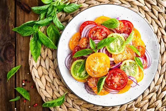 Tomato salad. Fresh vegetable salad with tomatoes, onion and basil