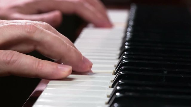 Virtuoso Playing the Piano. Female fingers close-up slowly touch the piano keys, extracting a simple melody. Filmed at a speed of 120fps