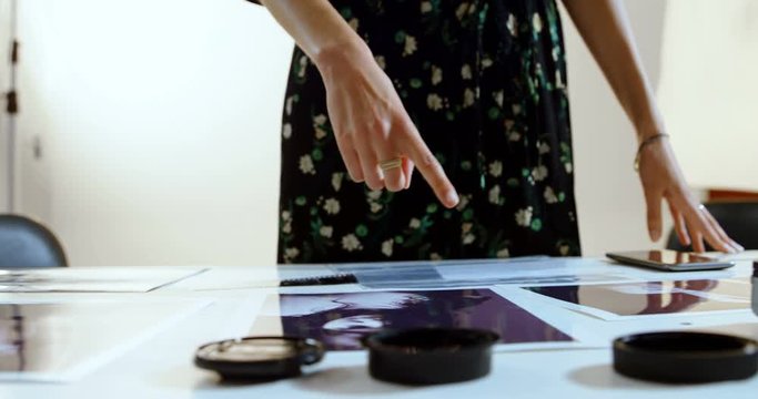 Female photographer looking photos on desk 4k