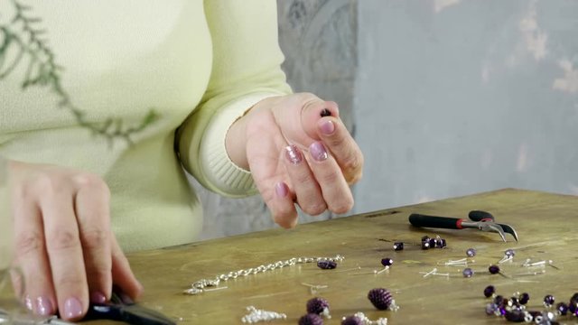 Master jeweler doing women's handmade bracelet from decorative artificial stones and beads. 4K