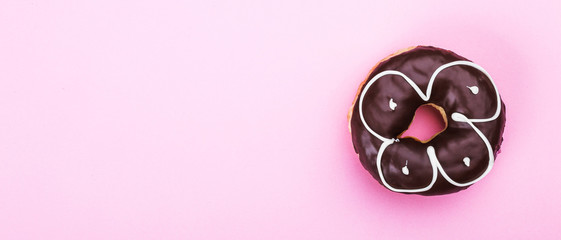 Delicious donut with chocolate isolated on pink background. Top viewand copy space