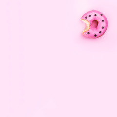 Freshly eaten donut isolated on pink background, top view and copy space