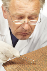 Scientist exploring ancient type of Akkad empire style cuneiform with tweezers