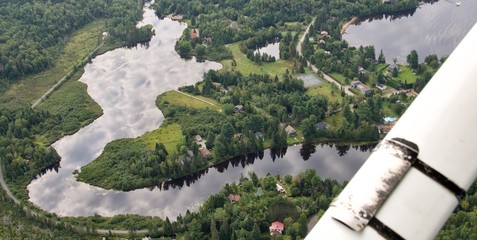 Clouds reflected in the water. Shot from a plane during the summer in Quebec Canada.