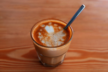 Small glass of iced coffee on wooden table