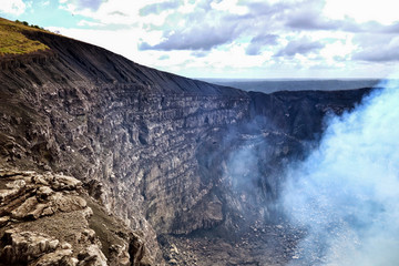The dramatic sheer walls of Volcan Masaya's smoking crater, near the colonial city of Granada in Nicaragua
