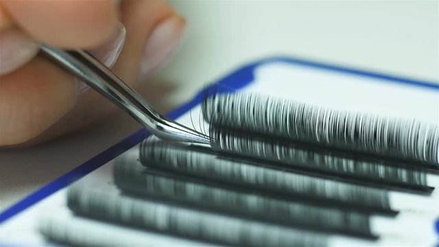 Artificial eyelash extensions material close-up of a master at work hd