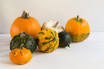 Orange halloween pumpkins on white planks, holiday decoration, close up