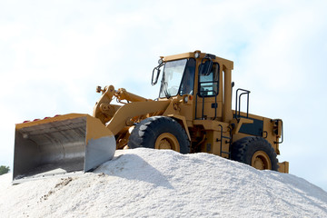 Bulldozer on salt mountain in industrial salt marsh