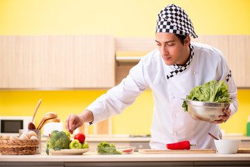 Young professional cook preparing salad at home
