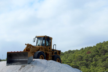 Bulldozer on salt mountain in industrial salt marsh