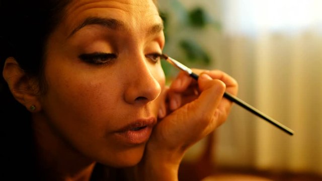 Female video blogger applying eyeshdow at home 4k