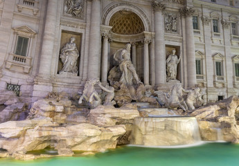 Fototapeta na wymiar Close up of the Trevi fountain (fontana di trei) in Rome at night. The statues ares above the turquoise water.