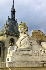 Fototapeta na wymiar Sphinx statue in front of Palace of Chantilly in golden afternoon light