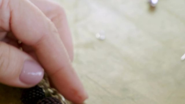 The young woman creating handmade jewelry bracelet in the studio. 4K