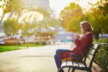 Beautiful young French woman near the Eiffel tower in Paris