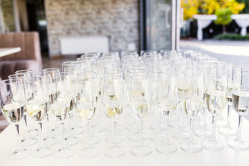 Full cold champagne flutes stand between buckets on dinner table