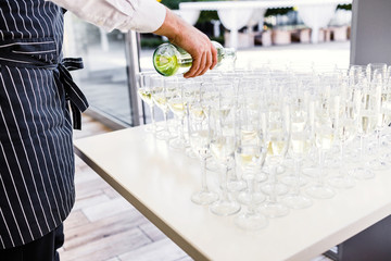 Elegant glasses with champagne standing in a row on serving tabl