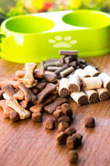 Dog tasty colored biscuits on wooden background, bowl