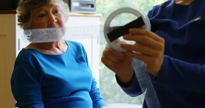 Physiotherapist examining senior woman knee with goniometer 4k