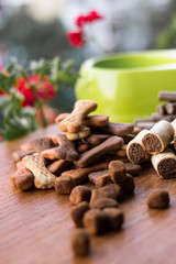 Dog tasty colored biscuits on wooden background, bowl
